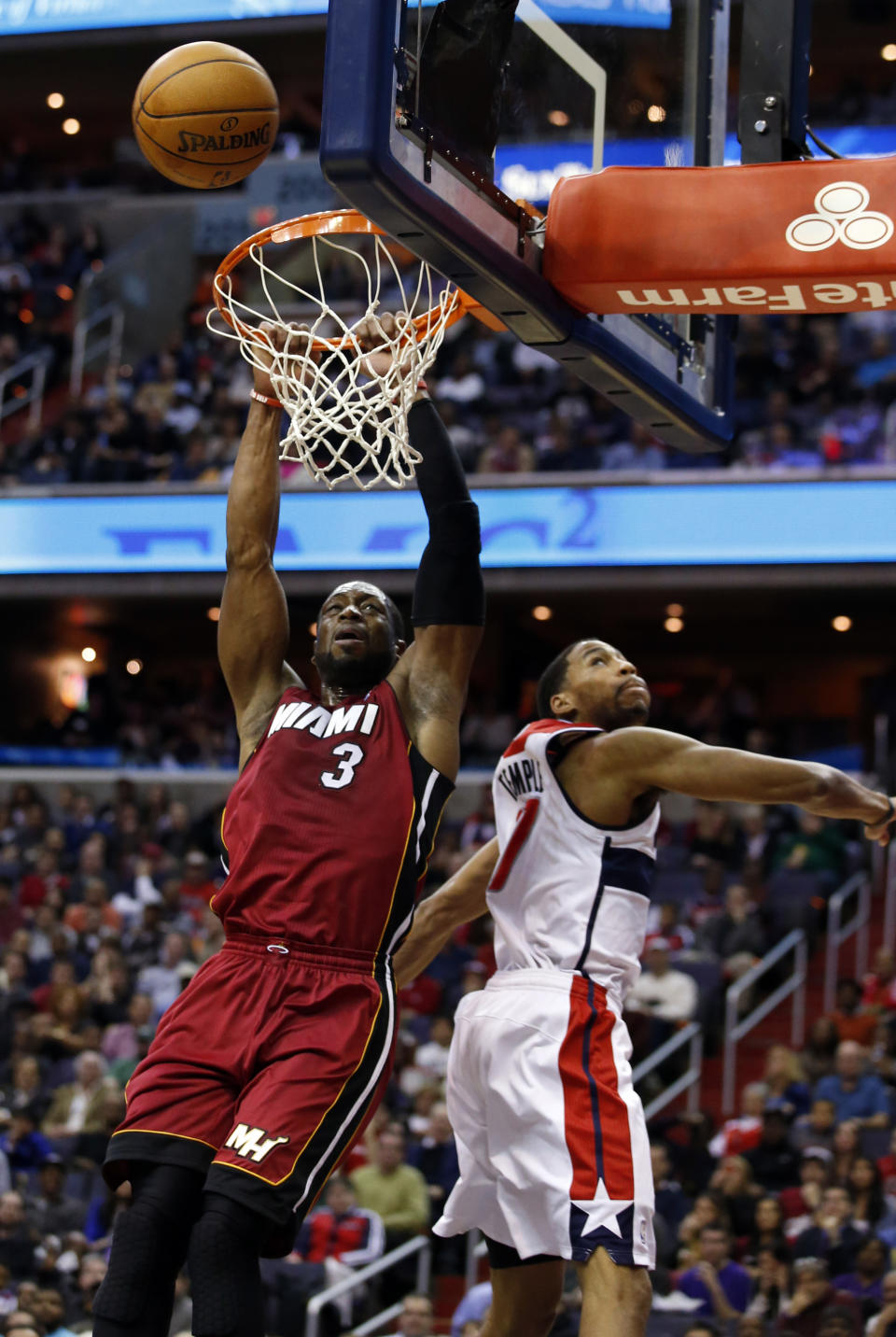 Miami Heat guard Dwyane Wade (3) misses a dunk in front of Washington Wizards guard Garrett Temple (17) in the first half of an NBA basketball game on Wednesday, Jan. 15, 2014, in Washington. (AP Photo/Alex Brandon)