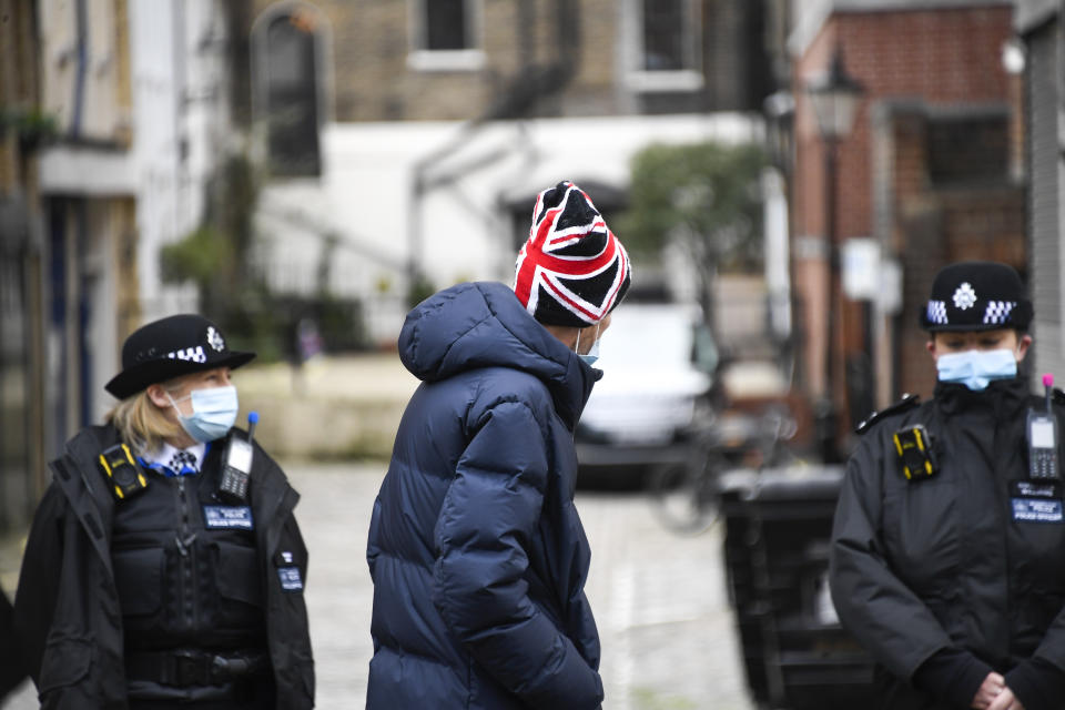 A member of the public wearing a Union Flag themed hat walks past the side entrance of the King Edward VII Hospital in London, Sunday, Feb. 21, 2021. Buckingham Palace said the husband of Queen Elizabeth II, 99-year-old Prince Philip was admitted to the private King Edward VII Hospital on Tuesday evening after feeling unwell. (AP Photo/Alberto Pezzali)