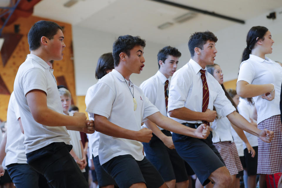 FILE - In this March 20, 2019, file photo, students perform the Haka on the arrival of New Zealand's Prime Minister Jacinda Ardern during a high school visit in Christchurch, New Zealand. Day after day, the students of Christchurch have gathered, feet smashing the ground in unison as they chant the words of their nation's indigenous people in an outpouring of grief and love and support. In the aftermath of a white supremacist's deadly shooting spree on two mosques on March 15, the young people of Christchurch have found solace in an old tradition: a Maori ceremonial dance called the haka. (AP Photo/Vincent Thian, File)