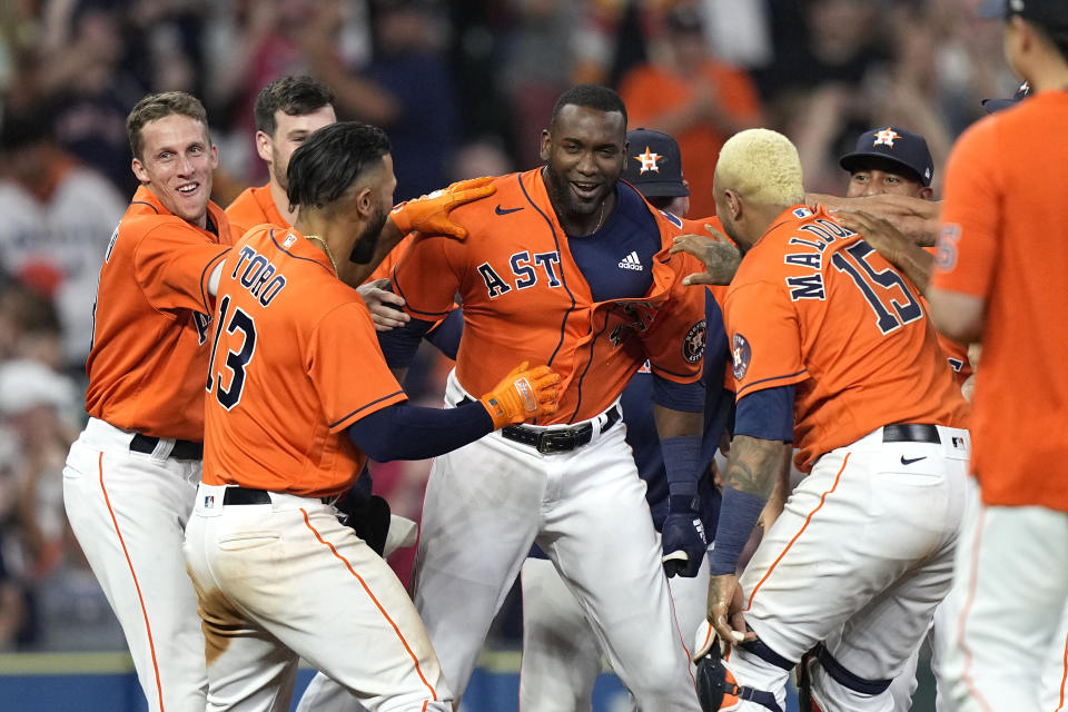 Houston Astros' Yordan Alvarez, center, celebrates with teammates after hitting a game-winning RBI-double during the ninth inning of a baseball game against the Chicago White Sox Friday, June 18, 2021, in Houston. The Astros won 2-1. (AP Photo/David J. Phillip)