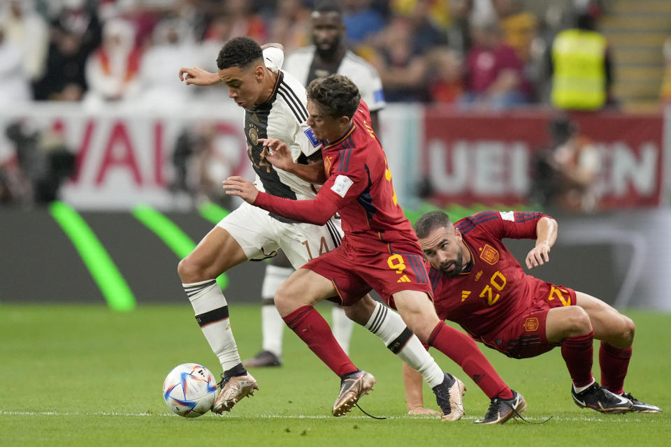 Spain's Gavi vies for the ball with Germany's Jamal Musiala, left, during the World Cup group E soccer match between Spain and Germany, at the Al Bayt Stadium in Al Khor , Qatar, Sunday, Nov. 27, 2022. (AP Photo/Matthias Schrader)