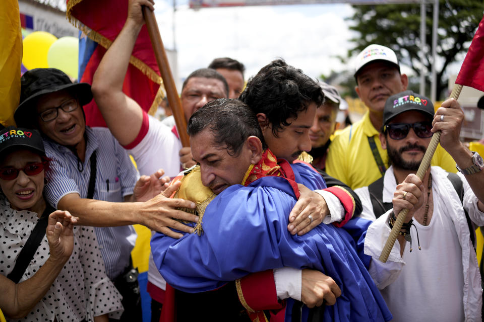 Men enacting as independence heroes Simon Bolivar and Francisco de Paula Santander embrace during an event organized by supporters of Colombia's new President Gustavo Petro in San Antonio, Venezuela, Sunday, Aug. 7, 2022. Colombia's incoming foreign minister and his Venezuelan counterpart announced in late July that the border, partially closed since 2015, will gradually reopen after the two nations restore diplomatic ties when Colombia's new president is sworn-in on Aug. 7. (AP Photo/Matias Delacroix)