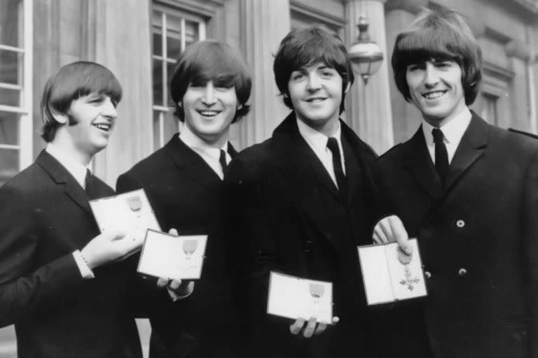 En esta foto de archivo del 26 de octubre de 1965, The Beatles, de izquierda a derecha: Ringo Starr, John Lennon, Paul McCartney y George Harrison sonríen mientras muestran las medallas de Miembro de la Orden del Imperio Británico que les entregó la reina Isabel II en una ceremonia. en el Palacio de