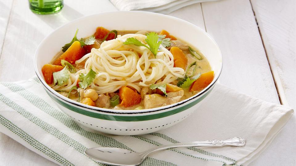 butternut squash apricot chicken noodle curry in two bowls with fresh cilantro on top