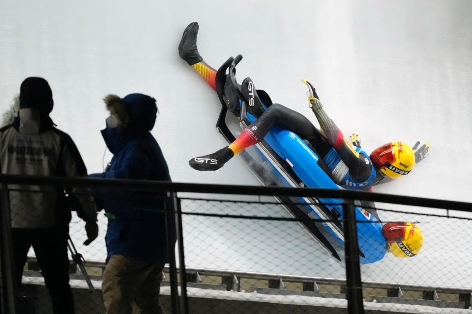 Two German athletes suffer a crash during a luge event.