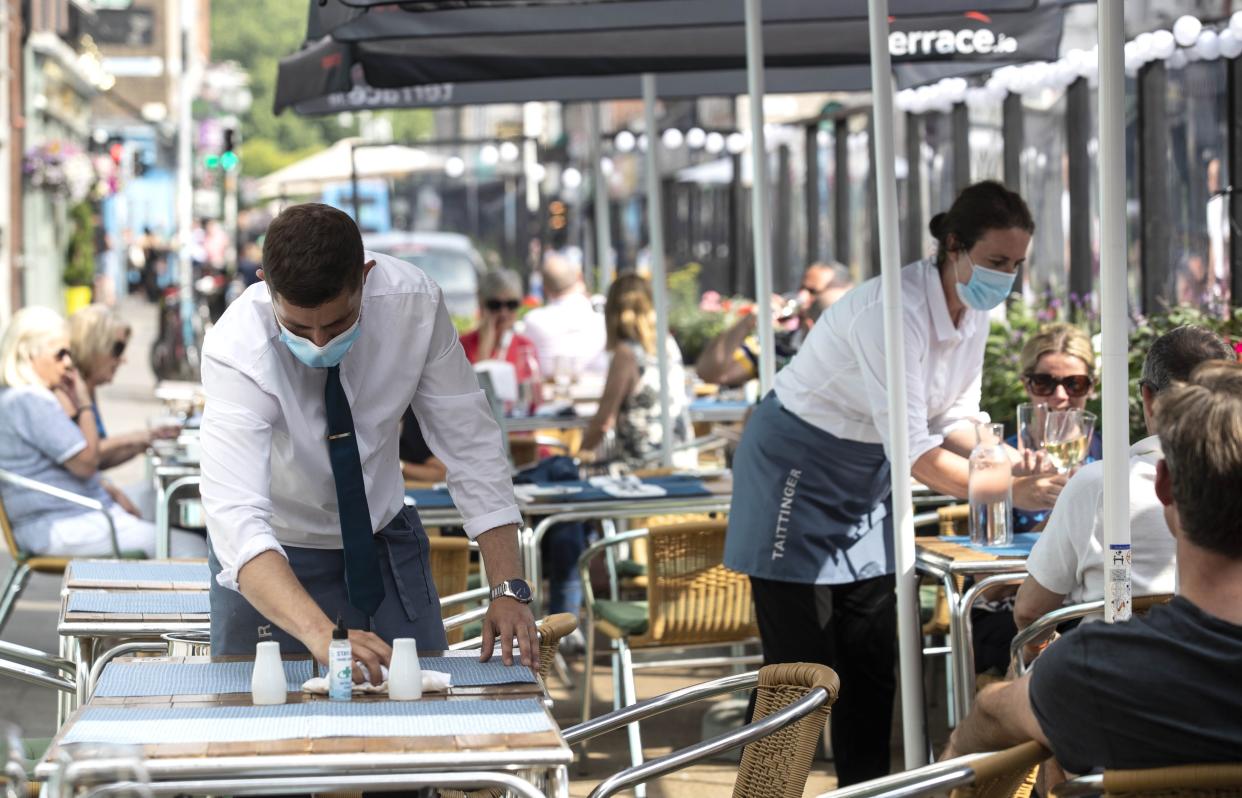 A waiter sets a table outside Hugos restaurant on Merrion Row in Dublin, where they will reopen for indoor dining on Thursday July 29.