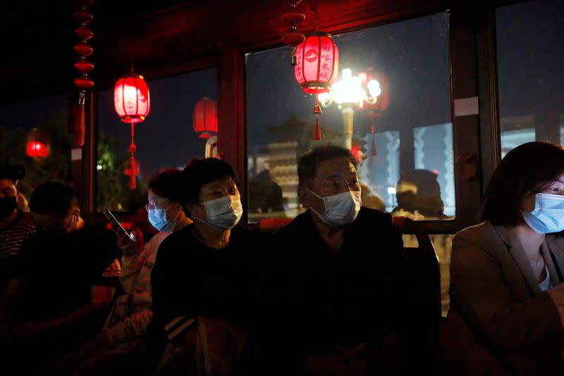 FILE PHOTO: Passengers sit in a sightseeing bus in Beijing