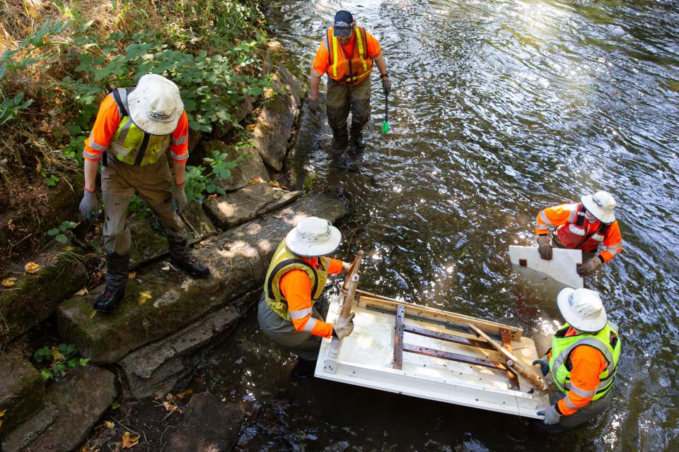 Salem's Stream Cleaning Program crew removes a table from Mill Creek on Thursday, July 18, 2024, in Salem, Ore.