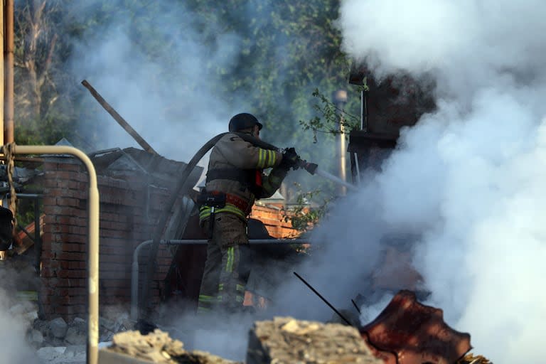 Los bomberos apagan una casa después de un ataque con misiles rusos contra Járkov, al noreste de Ucrania
