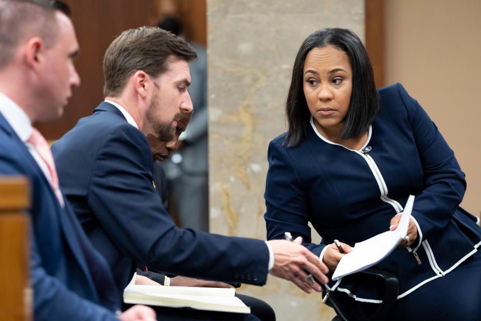 FILE - Fulton County District Attorney Fani Willis, right, talks with a member of her team during proceedings to seat a special purpose grand jury in Fulton County, Georgia, on May 2, 2022, to look into the actions of former President Donald Trump and his supporters who tried to overturn the results of the 2020 election. The hearing took place in Atlanta. (AP Photo/Ben Gray, File) ORG XMIT: WX103