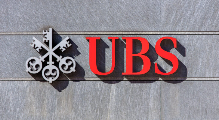 UBS (UBS) bank sign on gray stone wall with red and gray logo