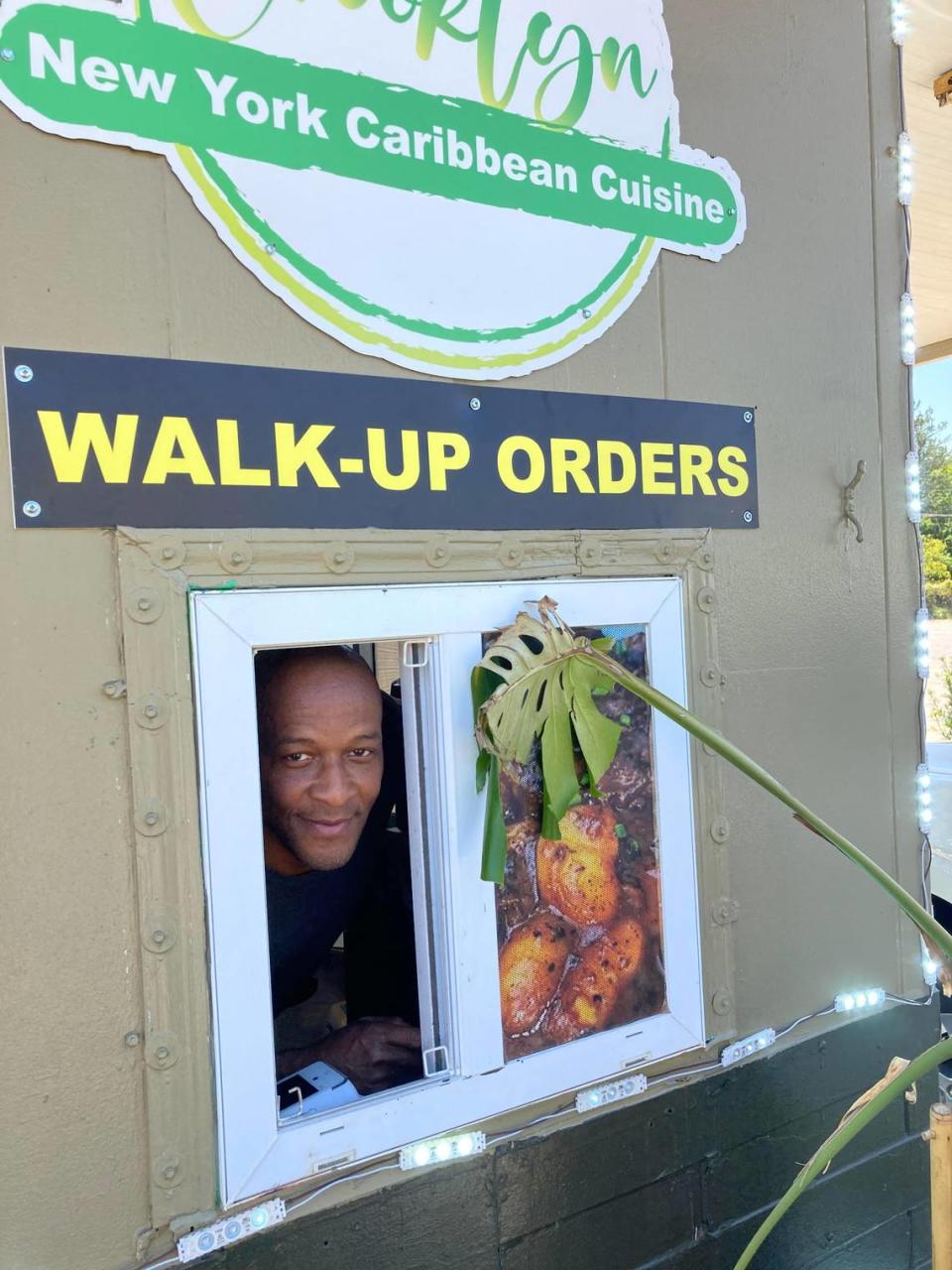 Crooklyn New York Caribbean Cuisine co-owner and chef Winston Cunningham looks out the walk-up window of their family restaurant.