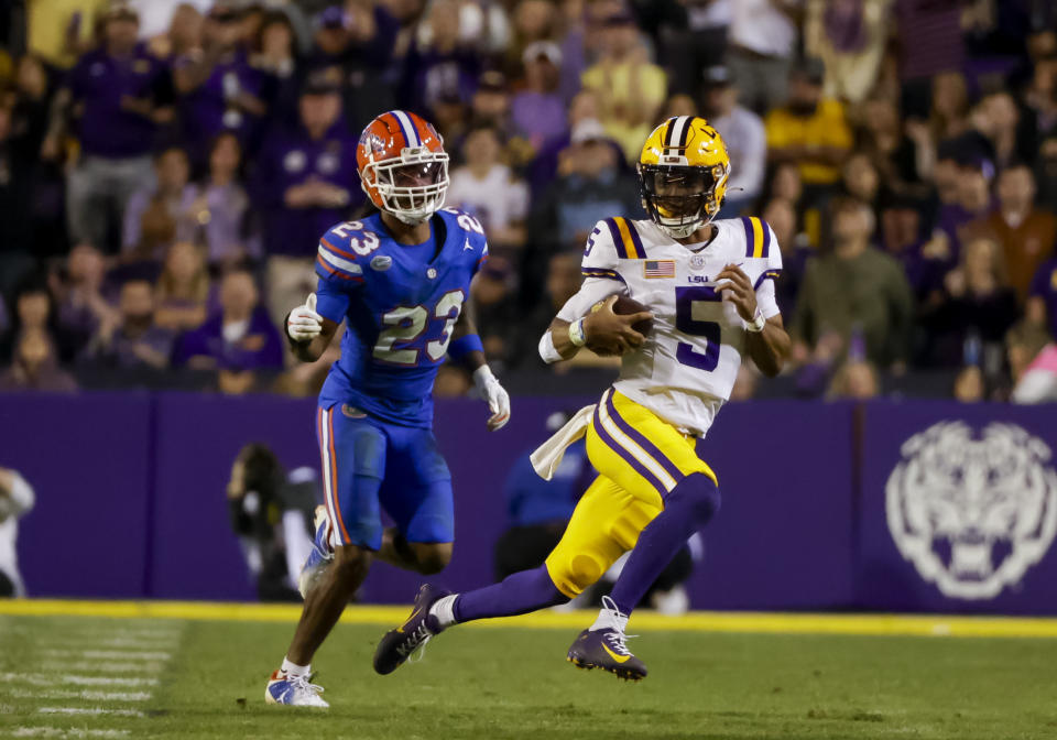 LSU quarterback Jayden Daniels (5) runs from Florida cornerback Jaydon Hill (23) during the second half of an NCAA college football game in Baton Rouge, La., Saturday, Nov. 11, 2023. (AP Photo/Derick Hingle)