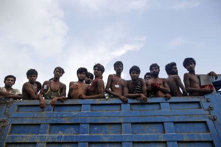 Migrants, who were found at sea on a boat, sit at the back of a truck as they are moved to Taung Pyo sub-township after landing near Kanyin Chaung jetty outside Maungdaw township, northern Rakhine state, Myanmar June 3, 2015. REUTERS/Soe Zeya Tun