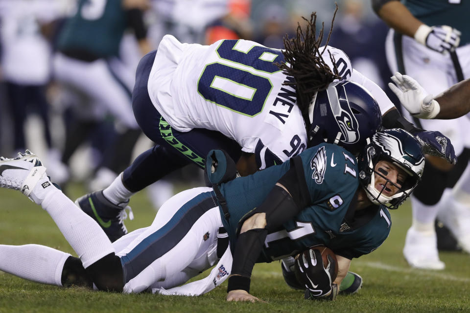 Seattle Seahawks' Jadeveon Clowney (90) hits Philadelphia Eagles' Carson Wentz (11) during the first half of an NFL wild-card playoff football game, Sunday, Jan. 5, 2020, in Philadelphia. Wentz was injured on the play. (AP Photo/Julio Cortez)