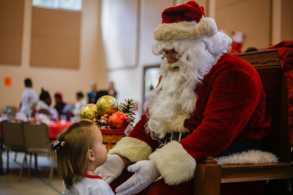 Aria, 2, meets Santa Claus during the 23rd annual "Christmas for the Community" holiday celebration at the University City Church of Christ in Gainesville on Dec. 8, 2019. This year's event will be held Dec. 11 from noon to 1:30 p.m.