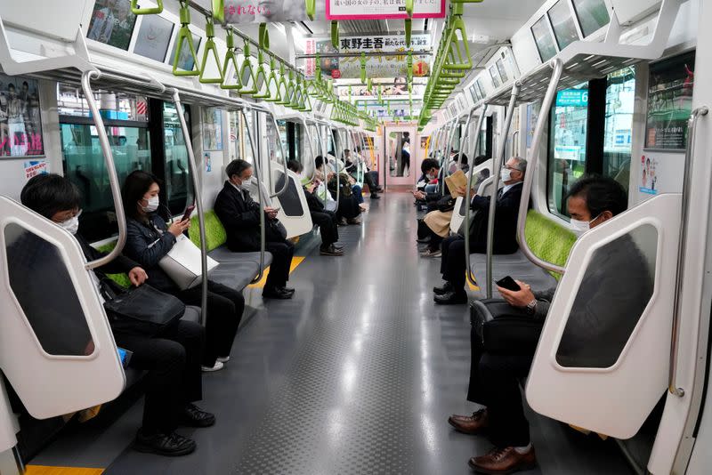 Passengers, wearing protective masks ride train, following outbreak of coronavirus disease (COVID-19), in Tokyo