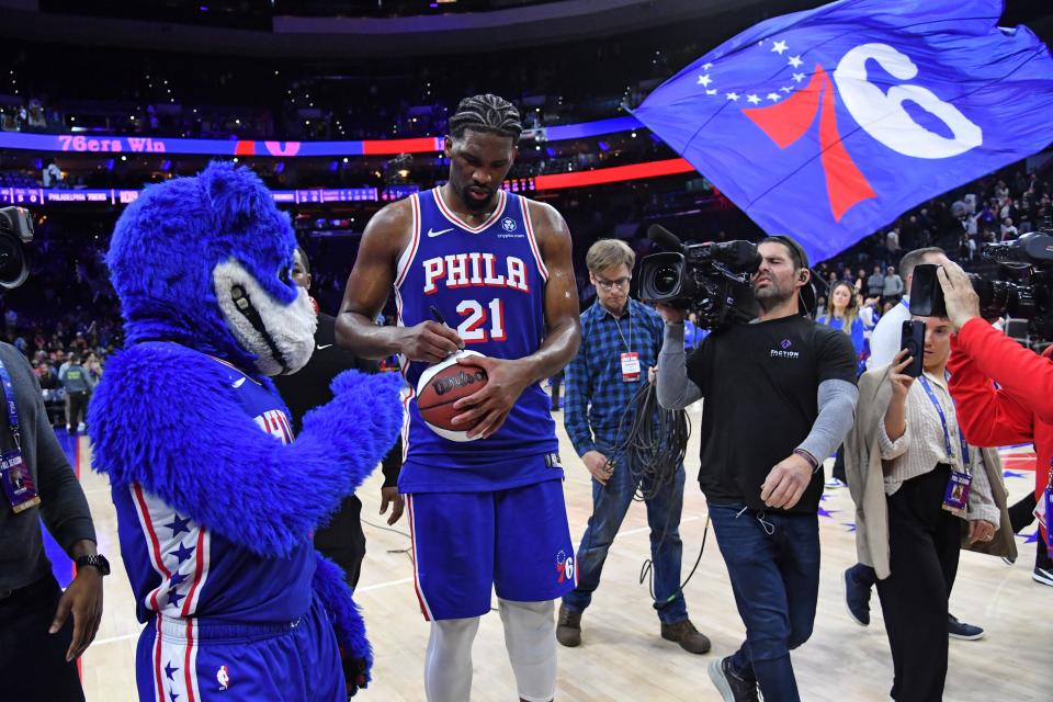 Apr 2, 2024; Philadelphia, Pennsylvania, USA; Philadelphia 76ers center Joel Embiid (21) autographs a basketball as he celebrates win against the Oklahoma City Thunder at Wells Fargo Center. Mandatory Credit: Eric Hartline-USA TODAY Sports ORG XMIT: IMAGN-719340 ORIG FILE ID: 20240402_eh_se7_01057.JPG