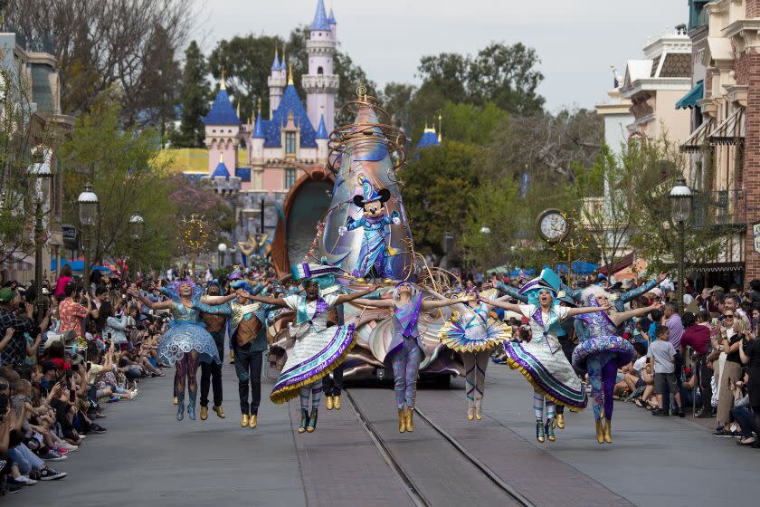 ANAHEIM, CALIF. -- THURSDAY, FEBRUARY 27, 2020: Dancers in vibrant, elaborate costumes join Mickey Mouse, dressed in the ''Sorcerer's Apprentice'' costume from Walt Disney's "Fantasia" movie, lead the new daytime parade titled "Magic Happens" of more than 90 dancers on Main Street U.S.A. on Thursday, Feb. 27, 2020 in Anaheim. Disneyland gave the media and Disneyland guests a sneak peak of the parade that will begin running for the general public Friday, Feb. 28. (Allen J. Schaben / Los Angeles Times)