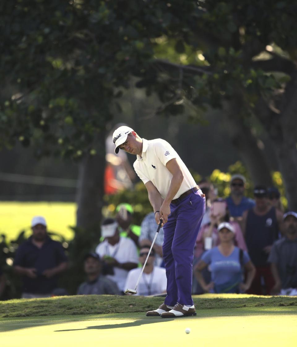 With a gallery behind him, Justin Thomas putts on the third green during the second round of the Sony Open golf tournament, Friday, Jan. 13, 2017, in Honolulu. (AP Photo/Marco Garcia)