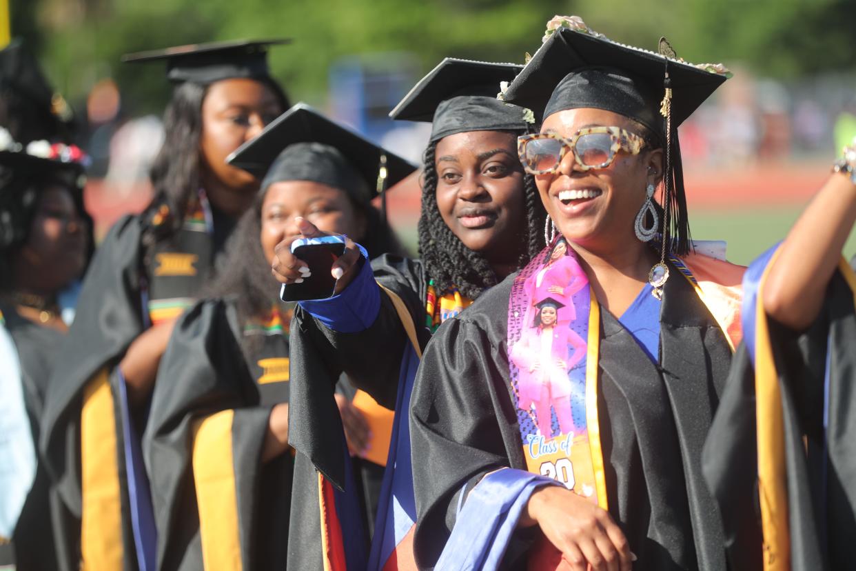 Graduates point to the stands during the Savannah State University Commencement ceremony on Friday, May 3, 2024 at TA Wright Stadium.