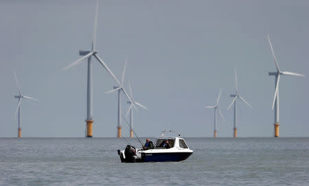 Two fishermen sit in their boat at the Gunfleet Sands Offshore Wind Farm near Clacton-on-Sea, Britain May 16, 2014. REUTERS/Suzanne Plunkett/File Photo