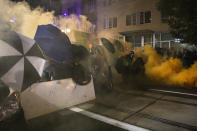 Tear gas fills the air during protests, Friday, Sept. 18, 2020, in Portland, Ore. The protests, which began over the killing of George Floyd, often result frequent clashes between protesters and law enforcement. (AP Photo/Paula Bronstein)