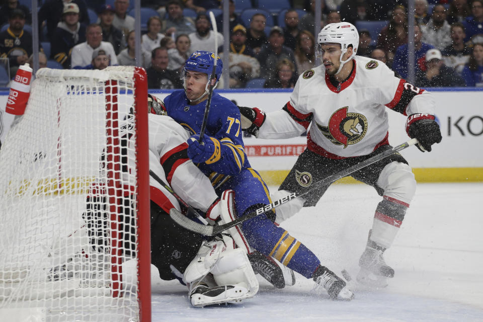 Buffalo Sabres right wing JJ Peterka (77) collides with Ottawa Senators goaltender Anton Forsberg while Senators defenseman Artem Zub (2) watches during the first period of an NHL hockey game Thursday, Oct. 13, 2022, in Buffalo, N.Y. (AP Photo/Joshua Bessex)