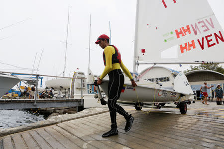 Venezuelan Olympic team sailor Jose Vicente Gutierrez launches his laser yacht at the Puerto Azul Club harbour in Naiguata, in the state of Vargas, Venezuela April 18, 2016. REUTERS/Marco Bello