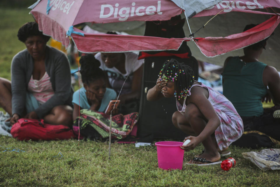 A girl washes her face after spending the night at a soccer field following Saturday´s 7.2 magnitude earthquake in Les Cayes, Haiti, Sunday, Aug. 15, 2021. (AP Photo/Joseph Odelyn)