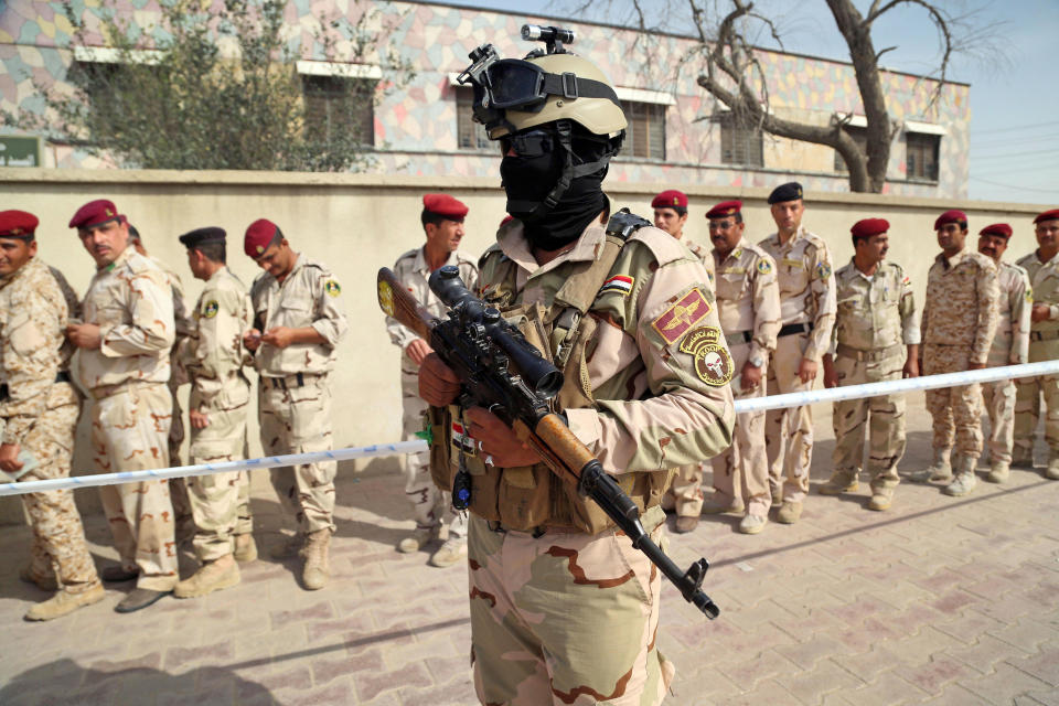 Security forces and army personnel queue to vote outside a polling center in Basra, Iraq's second-largest city, 340 miles (550 kilometers) southeast of Baghdad, Iraq, Monday, April 28, 2014. Amid tight security, some one million Iraqi army and police personnel have started voting for the nation's new parliament. (AP Photo/ Nabil al-Jurani))