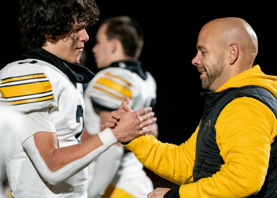 Central Bucks West quarterback Ganz Cooper and head coach Rob Rowan clasp hands after the PIAA District One Class 6A football championship game against Garnet Valley at Moe DeFrank Stadium in Collegeville on Friday, November 25, 2022. The Jaguars defeated the Bucks 35-7 for the district title.