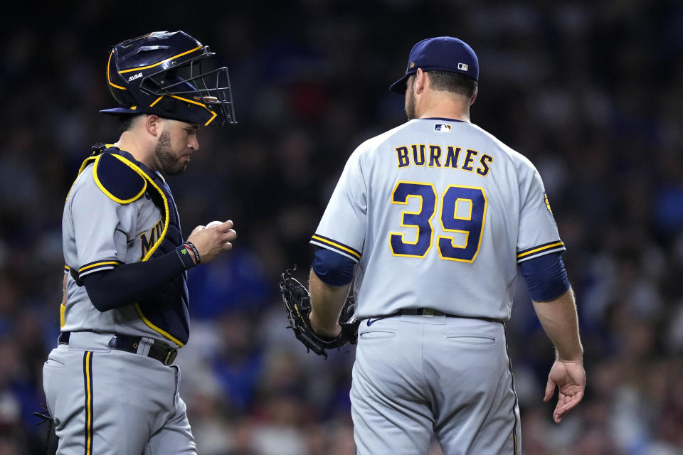 Milwaukee Brewers catcher Victor Caratini visits starting pitcher Corbin Burnes on the mound with the bases loaded during the fifth inning of the team's baseball game against the Chicago Cubs on Tuesday, Aug. 29, 2023, in Chicago. (AP Photo/Charles Rex Arbogast)
