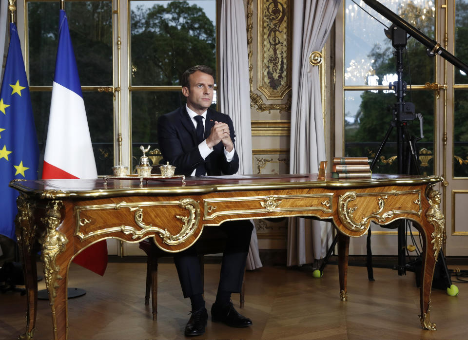 French President Emmanuel Macron sits at his desk after addressing the French nation following a massive fire at Notre Dame Cathedral, at Elysee Palace in Paris, Tuesday, April 16 2019. Macron said he wants to see the fire-ravaged Notre Dame cathedral to be rebuilt within five years. (Yoan Valat, Pool via AP)