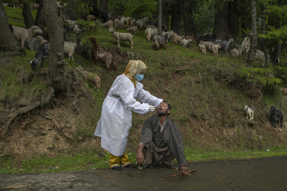 A Kashmiri doctor in protective suit takes a nasal swab sample of a nomad to test for COVID-19 in Budgam southwest of Srinagar, Indian controlled Kashmir, Tuesday, May 18, 2021. India’s total virus cases since the pandemic began swept past 25 million on Tuesday as the country registered more than 260,000 new cases and a record 4,329 fatalities in the past 24 hours. (AP Photo/ Dar Yasin)