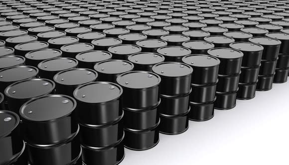 Collection of black oil barrels in a room with a white floor.