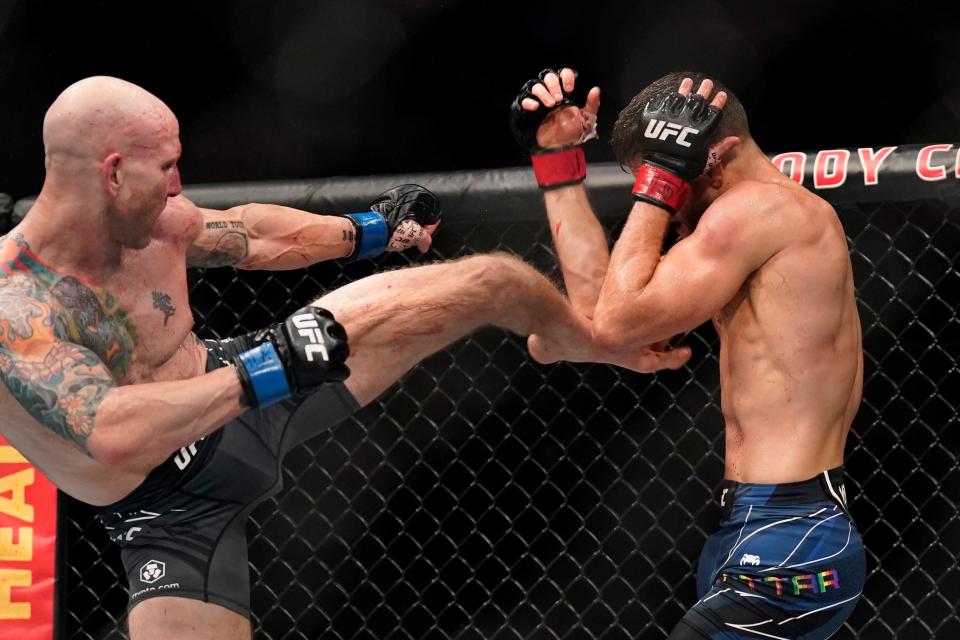 Josh Emmett (blue gloves) aims a kick at Calvin Kattar in the featherweight main event fight at UFC Fight Night in Austin, Texas in June 2022.