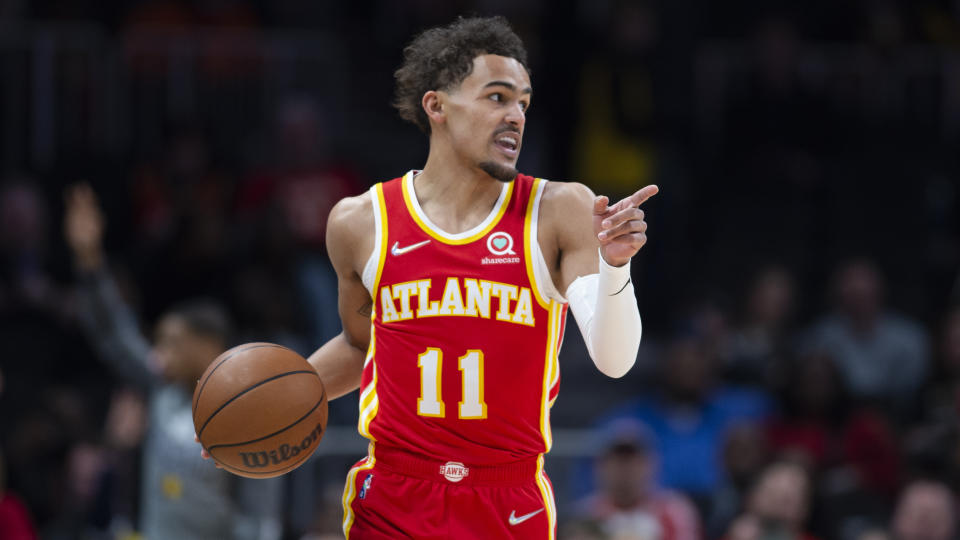 Atlanta Hawks guard Trae Young (11) points during the first half of an NBA basketball game against the Indiana Pacers Sunday, March 13, 2022, in Atlanta. (AP Photo/Hakim Wright Sr.)