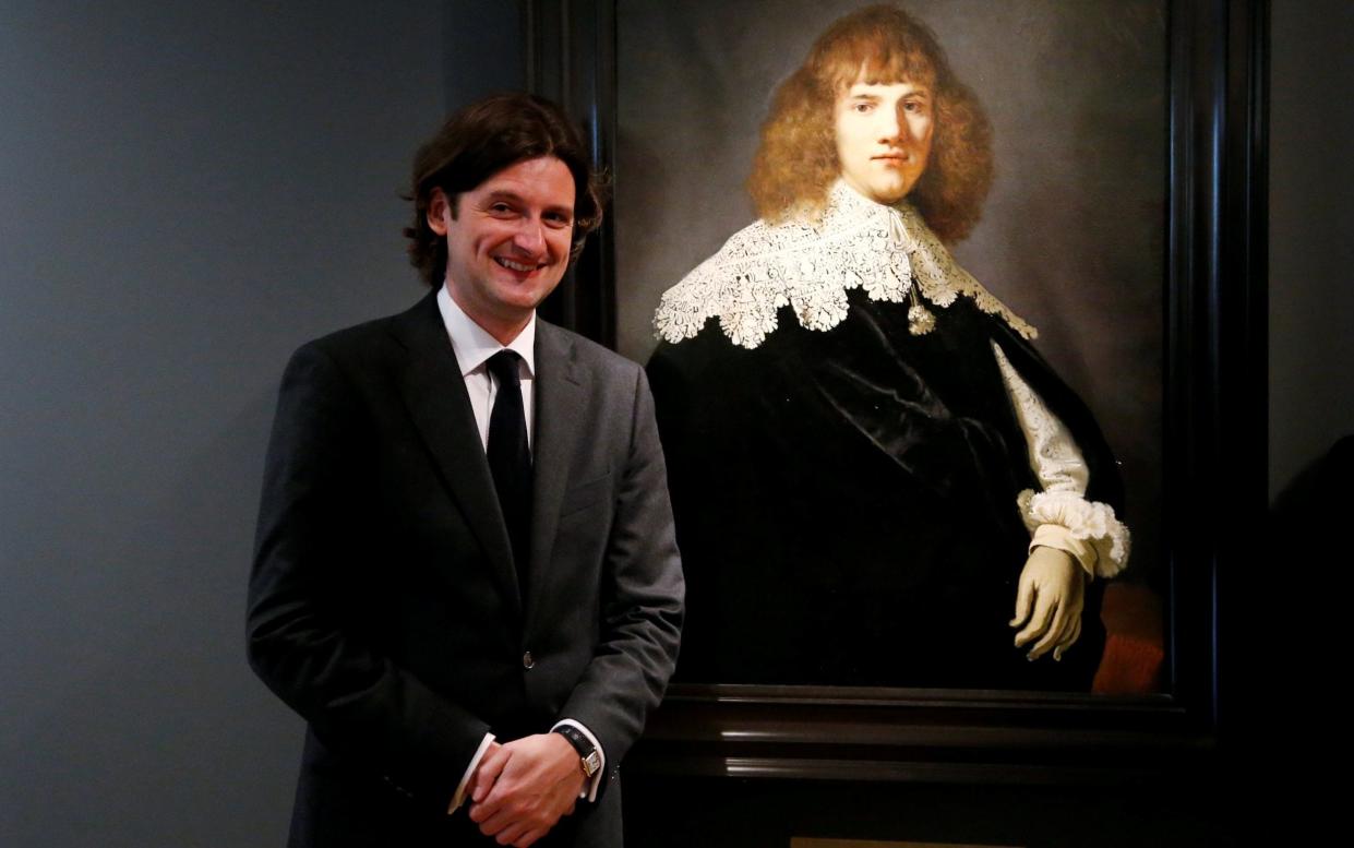 Art dealer Jan Six poses next to Portrait of a Young Man, a painting newly attributed to Rembrandt - REUTERS