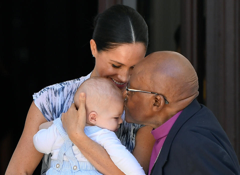 Baby Archie is kissed on the forehead by Archbishop Desmond Tutu while in the hands of his mother The Duchess of Sussex in cape Town, on day three of their tour of Africa.