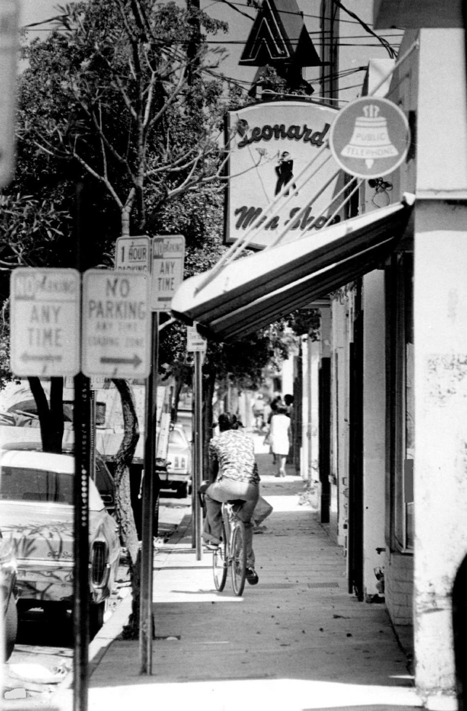 Grand Avenue fue durante mucho tiempo el corazón comercial de la sección históricamente afroamericana de Coconut Grove, en Miami. Por encima del ciclista de la acera se ve un cartel de una antigua sastrería para hombres.