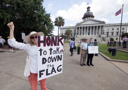 Sheila DiCiorrio holds a sign asking for the confederate battle flag that flies at the South Carolina State House to be removed in Columbia, SC June 20, 2015. REUTERS/Jason Miczek