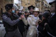 Ultra-Orthodox Jews some wearing costumes scuffle with police officers during celebrations of the Jewish holiday of Purim, in the Mea Shearim ultra-Orthodox neighborhood of Jerusalem, Sunday, Feb. 28, 2021. The Jewish holiday of Purim commemorates the Jews' salvation from genocide in ancient Persia, as recounted in the biblical Book of Esther. (AP Photo/Oded Balilty)