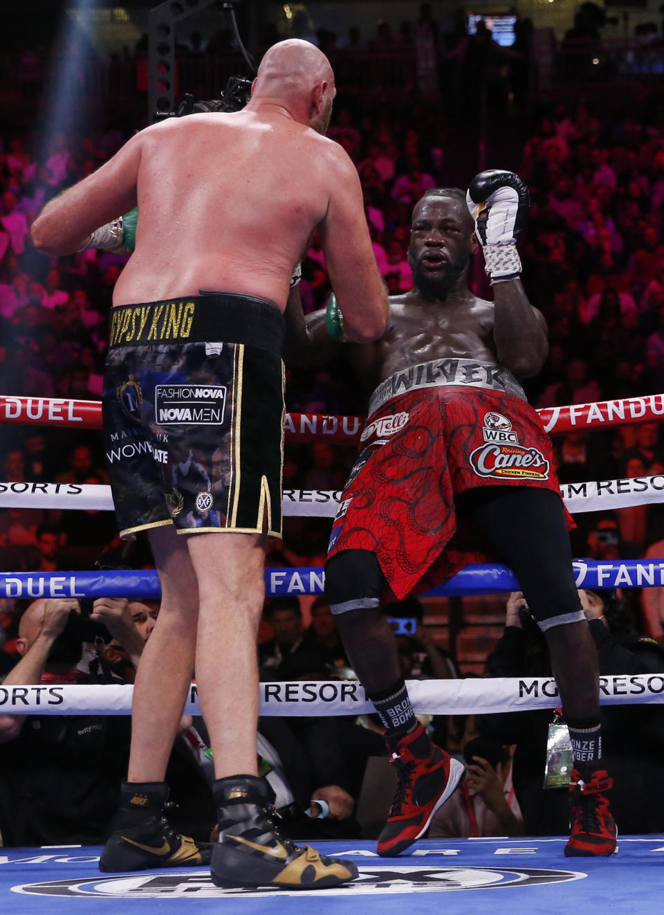 Tyson Fury, of England, hits Deontay Wilder onto the ropes in a heavyweight championship boxing match Saturday, Oct. 9, 2021, in Las Vegas. (AP Photo/Chase Stevens)