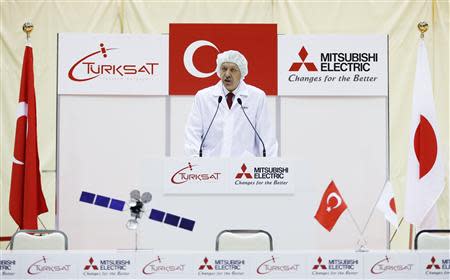 Turkey's Prime Minister Tayyip Erdogan, wearing a dust-free garment, delivers a speech during a ceremony to mark the shipment of the Turksat-4A satellite at Mitsubishi Electric Corp's Kamakura Works, the satellite production facility, in Kamakura, south of Tokyo January 8, 2014. REUTERS/Issei Kato