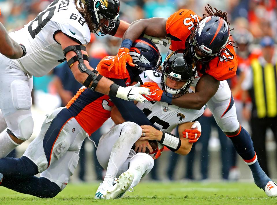 Jacksonville Jaguars quarterback Trevor Lawrence (16) is sacked by Denver Broncos outside linebacker Von Miller (58) and linebacker A.J. Johnson (45) during the second half at TIAA Bank Field on September 19, 2021. Mandatory Credit: Mark J. Rebilas-USA TODAY Sports