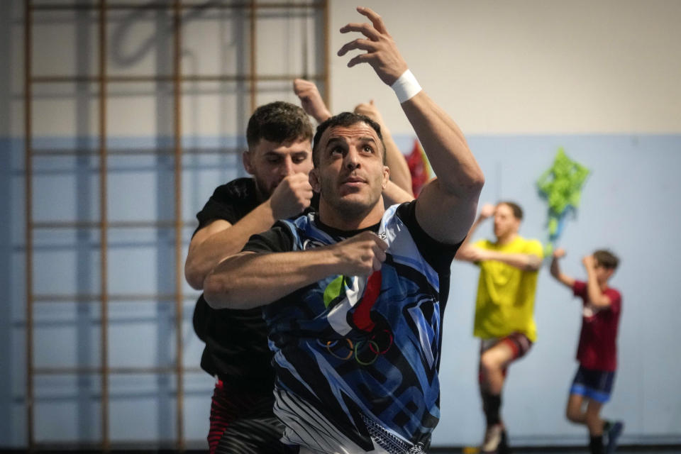 Iranian wrestler Iman Mahdavi, 28, practices at the Lotta Club Seggiano gym, in Pioltello, northern Italy, Wednesday, Feb. 28, 2024. Mahdavi fled his home country in fear of his life in October 2020. Now, he will compete in Paris as part of the Refugee Olympic Team. (AP Photo/Luca Bruno)