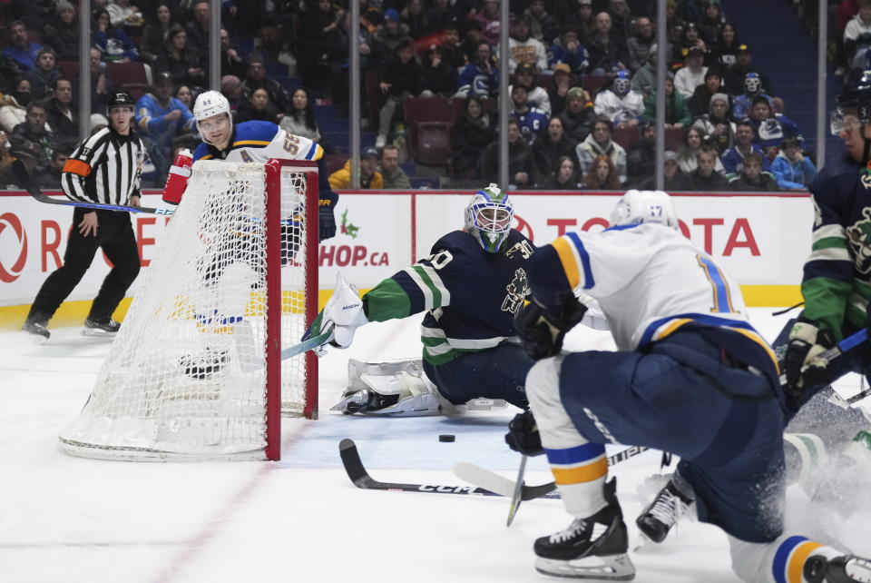 St. Louis Blues' Josh Leivo, front right, misses the open net behind Vancouver Canucks goalie Spencer Martin (30) during the second period of an NHL hockey game in Vancouver, British Columbia, on Monday, Dec. 19, 2022. (Darryl Dyck/The Canadian Press via AP)