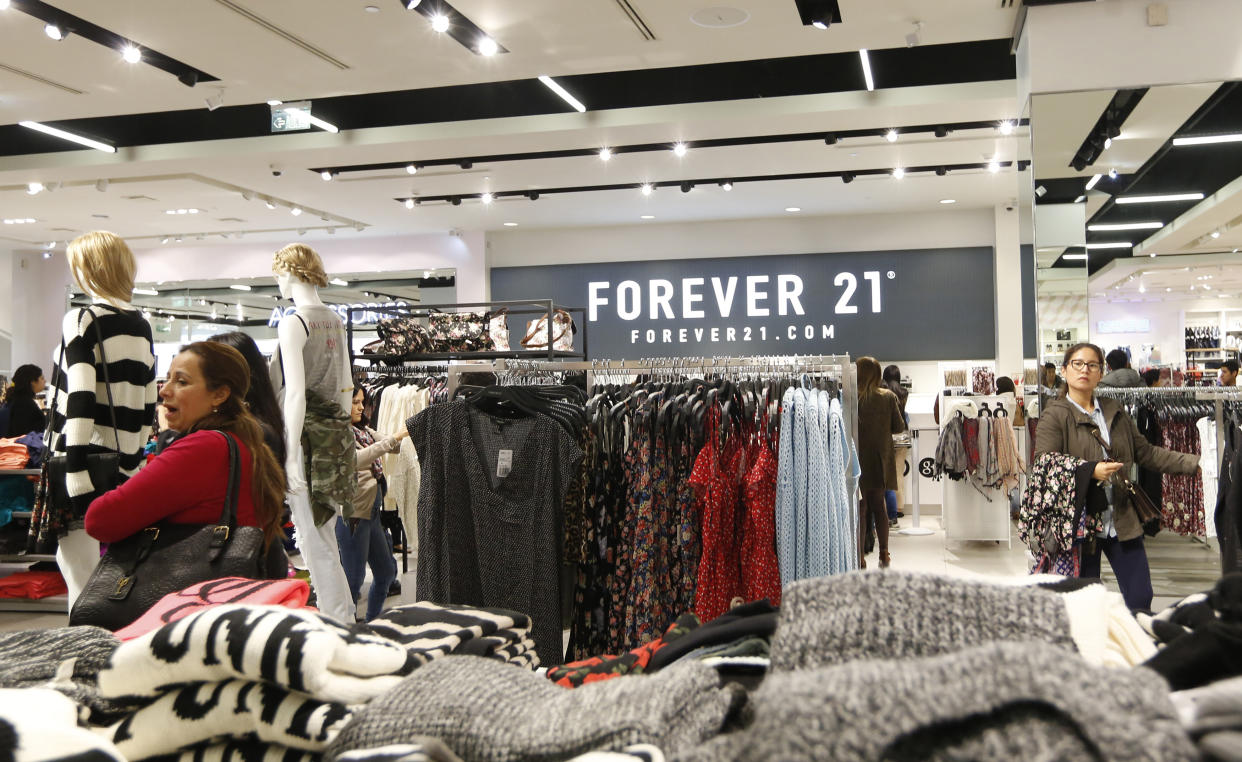 Customers browse through clothes at the first Forever 21 retail store in Lima, at Real Plaza Salaverry shopping mall October 1, 2014. Forever 21 opened its first store in Lima on September 27.  REUTERS/Mariana Bazo   (PERU - Tags: FASHION BUSINESS)