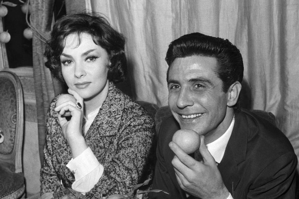 Gina Lollobrigida and French singer Gilbert Becaud pose after receiving the ‘Prix Orange’, awarded by a jury of journalists to the artists most cooperative with the press in Paris, in 1959 (AFP via Getty Images)